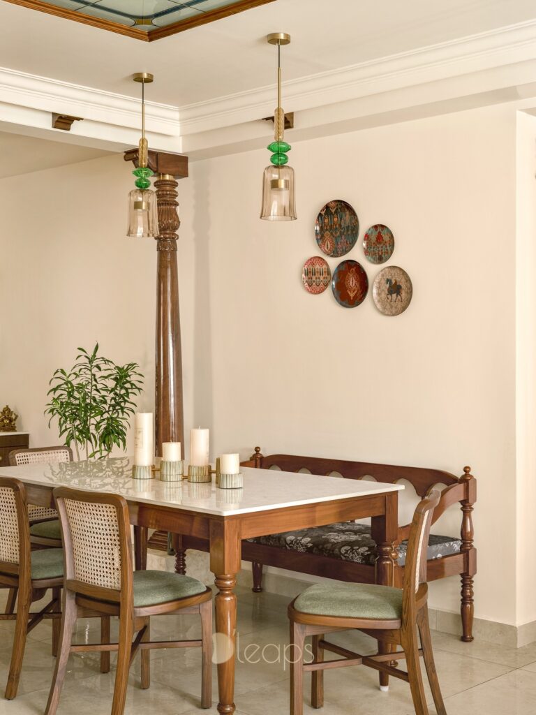 Teak dining table with cane chairs and glass pendant lights