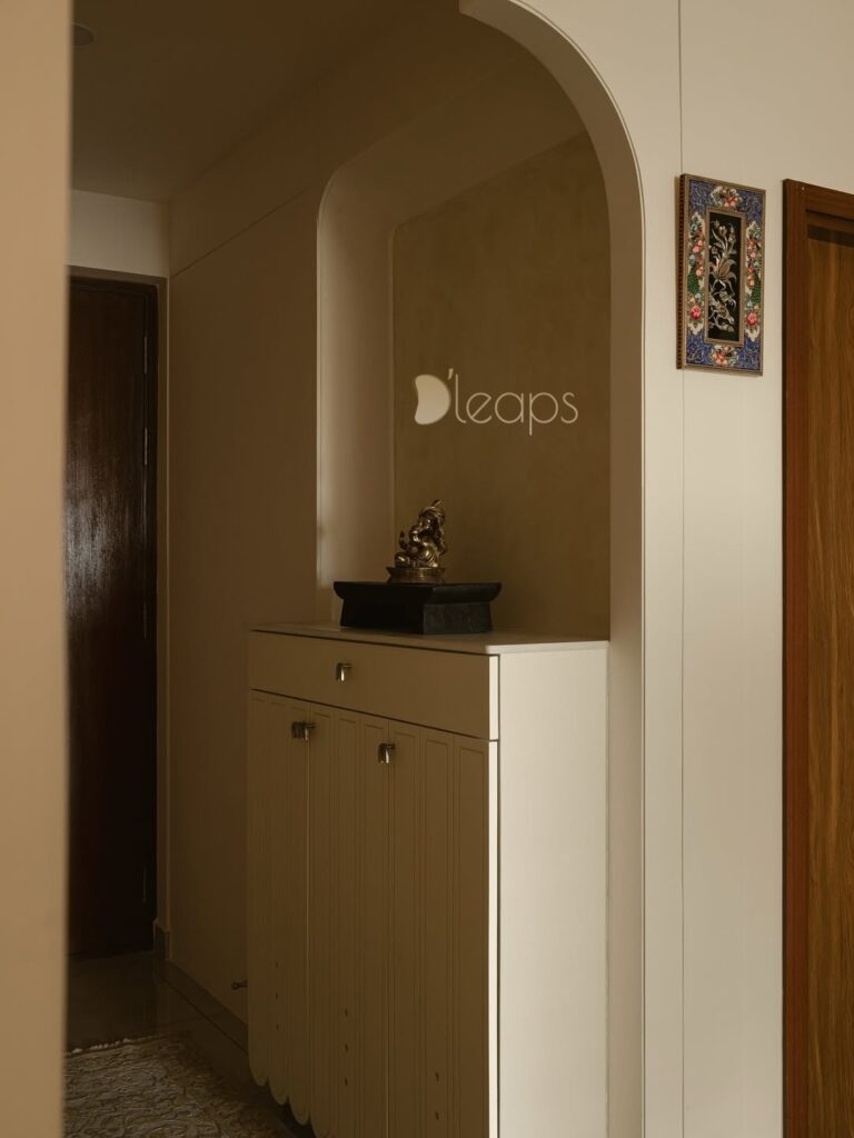 Foyer arch niche with brass Ganesha and concealed shoe storage