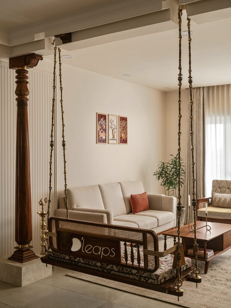Carved teak columns and brass jhoola in an Indian living room
